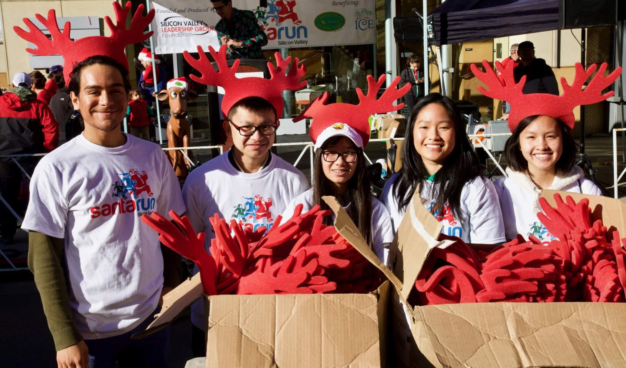 santa run silicon valley volunteers behind boxes of red reindeer hats
